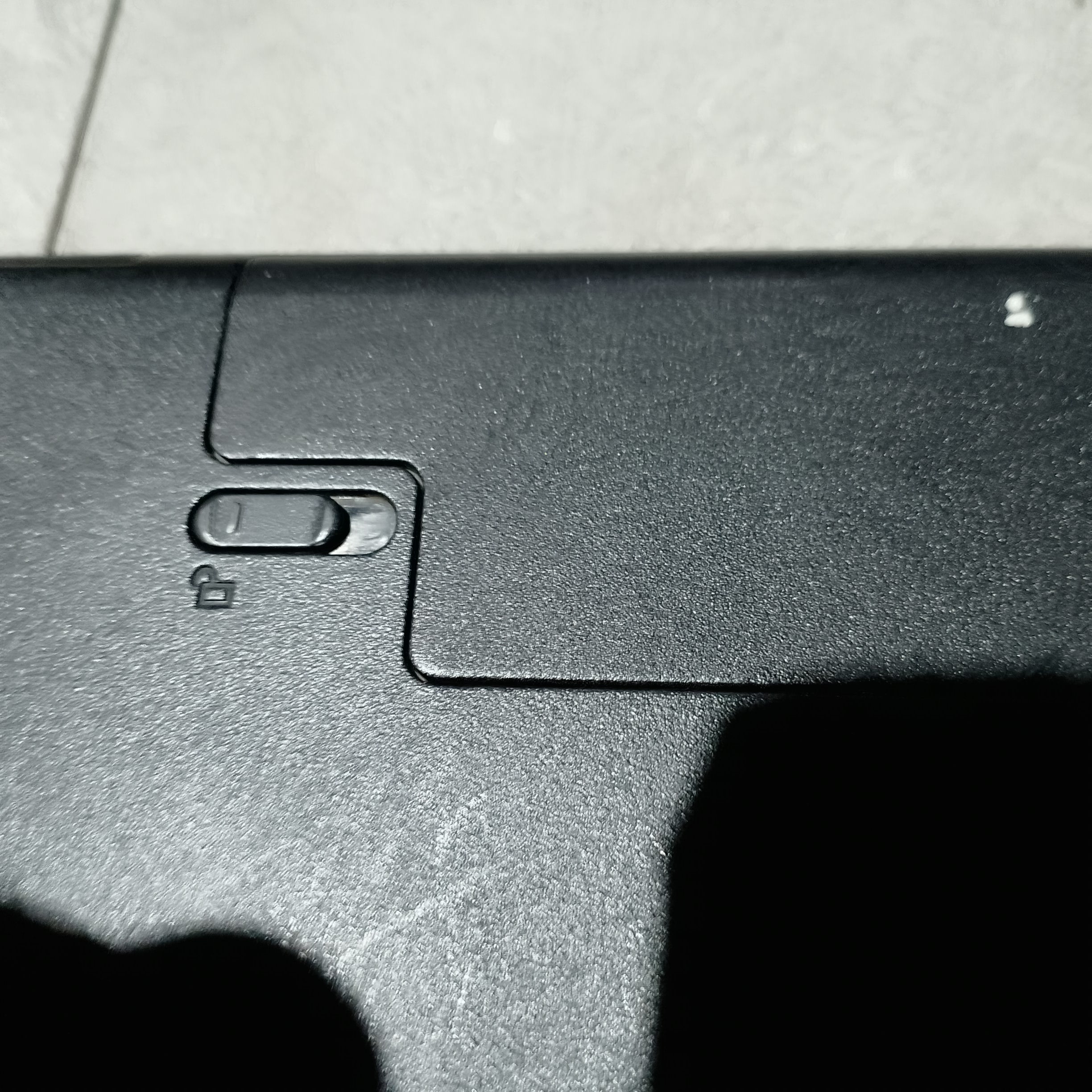 Левый фиксатор аккумулятора Dell P40F в положении Unlock