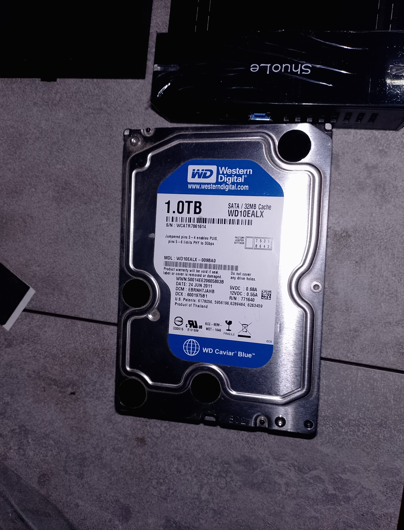 Жесткий диск WD Caviar Blue 1TB рядом с корпусом SHUOLE