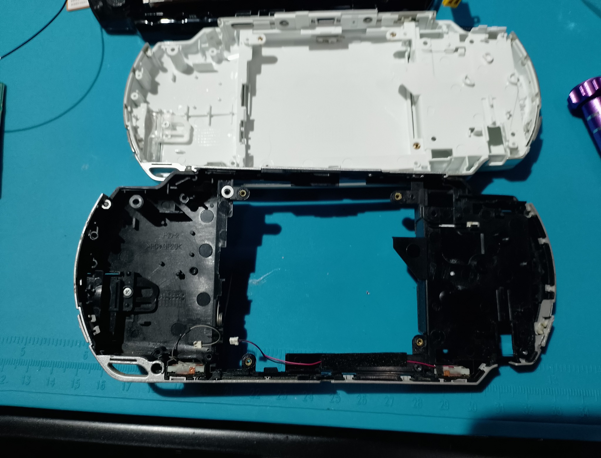 PSP-1004 замена корпуса - Старый чёрный нижний корпус и белая замена лежат рядом. Разница хорошо объясняет задумку: не полировка, а смена внешнего вида.