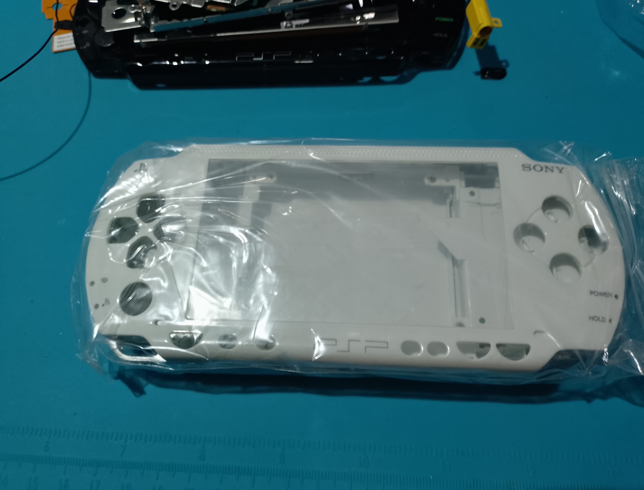 PSP-1004 замена корпуса - Белая задняя половина ещё в защитной упаковке. Пластик стоит осмотреть до установки, особенно углы и тонкие защёлки.