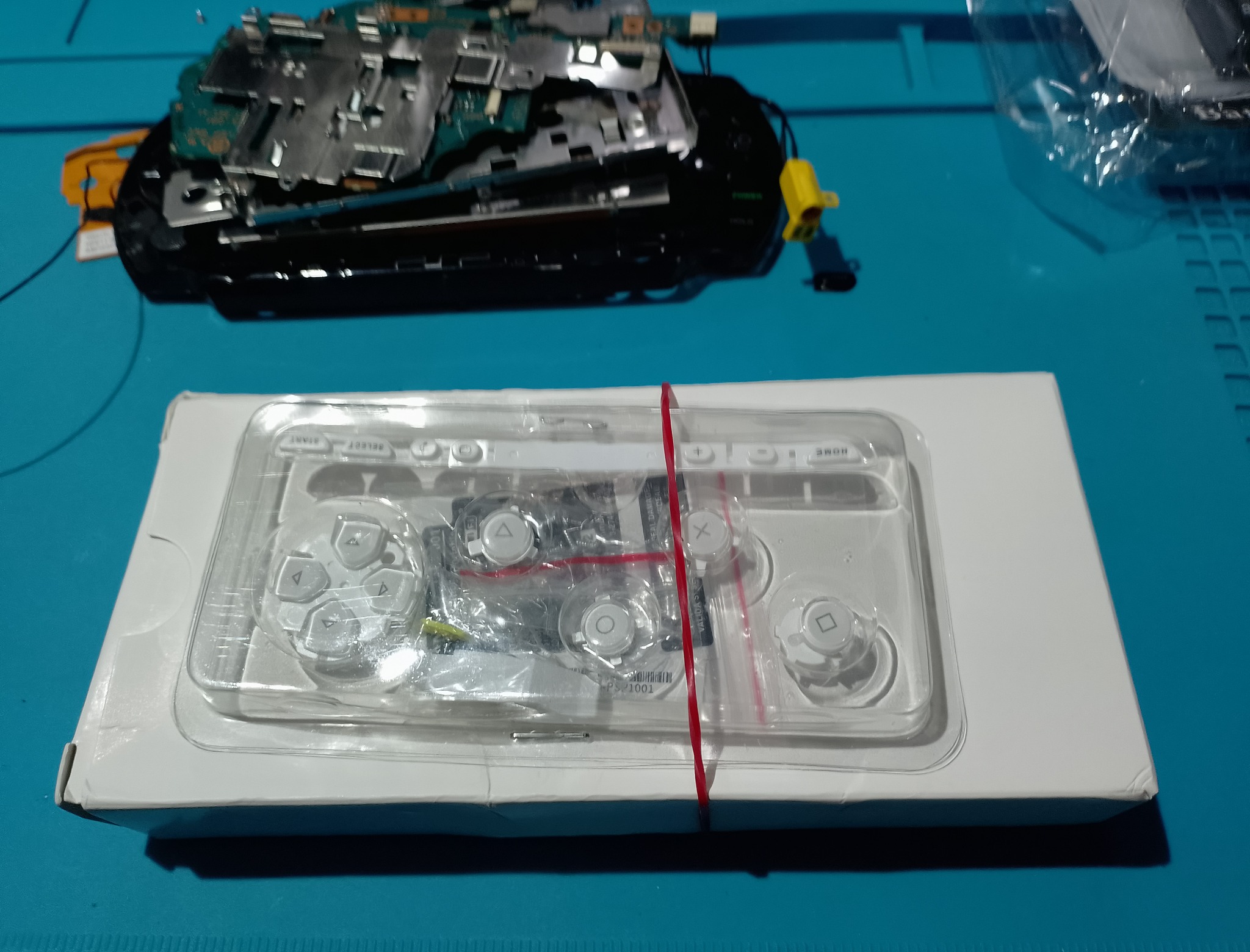 PSP-1004 замена корпуса - Новая белая лицевая панель лежит в блистере. В комплекте уже видны кнопки и прозрачное окно экрана.