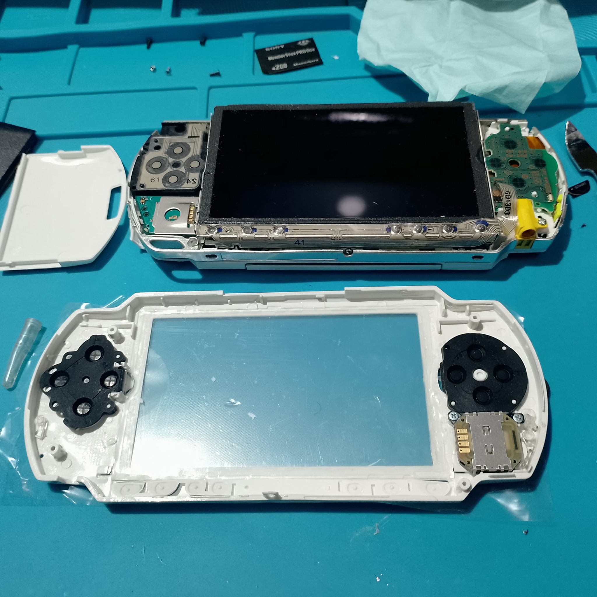 PSP-1004 замена корпуса - Белая лицевая панель примеряется рядом с экранным блоком. Перед затяжкой винтов надо убедиться, что кнопки лежат ровно.