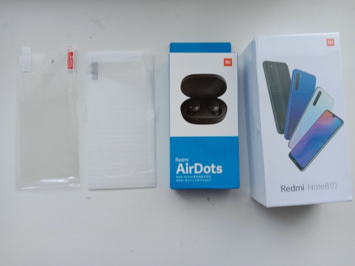 коробка Redmi Note 8T рядом с Redmi AirDots и защитными стеклами